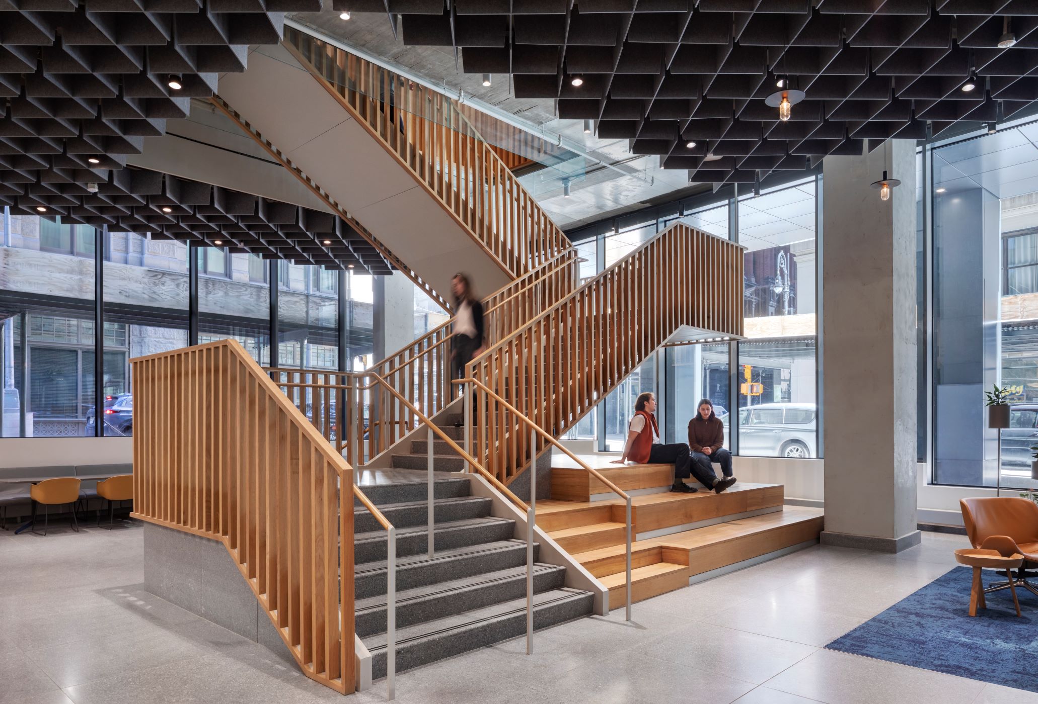large staircase with timber battons and students casually sitting