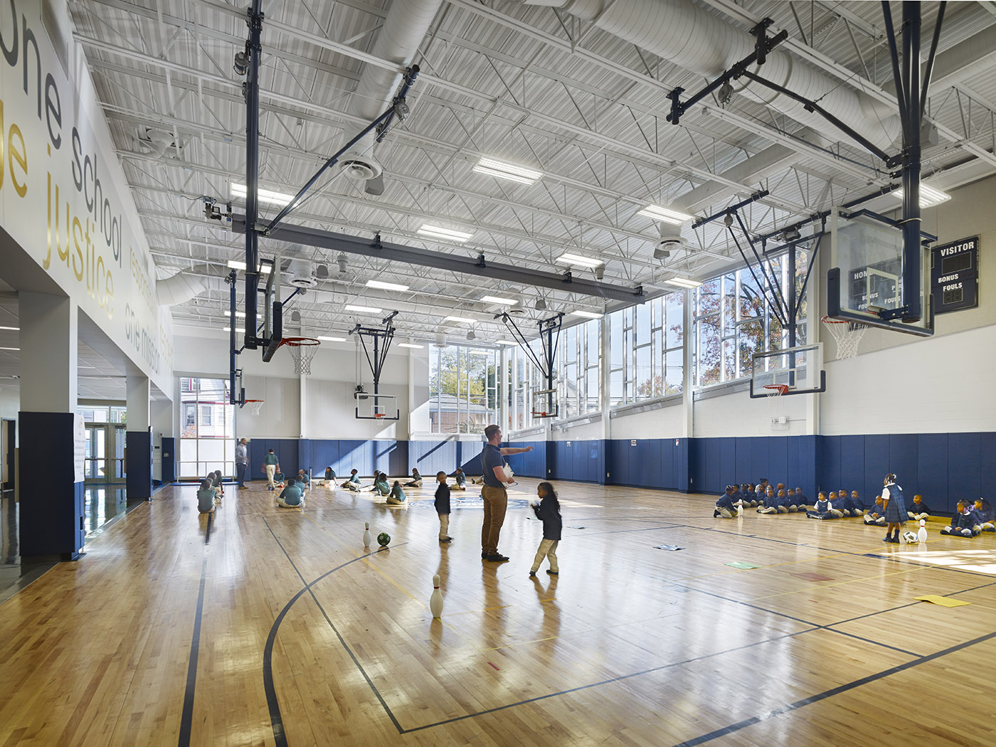 Children playing basketball in school gymnasium