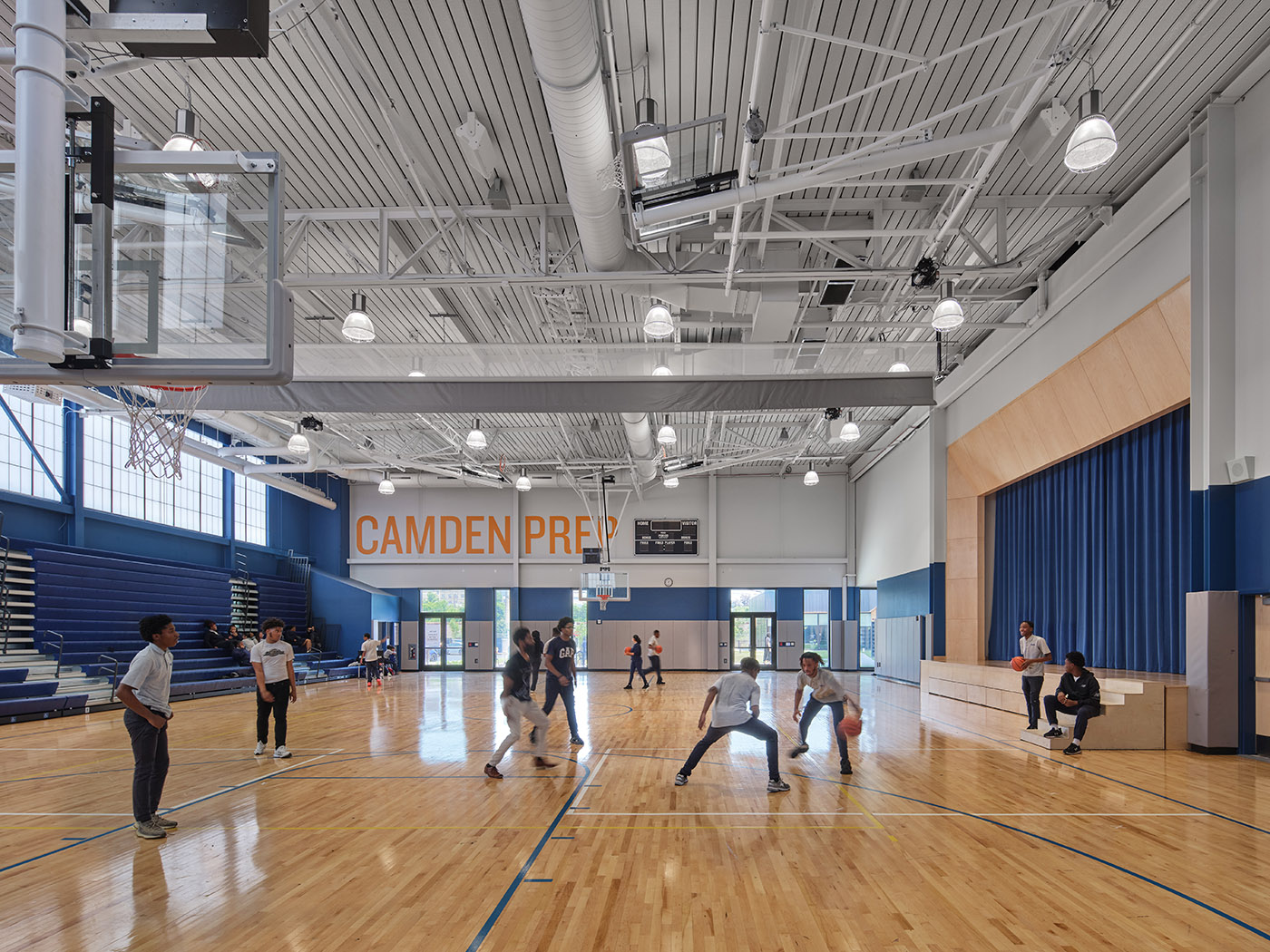 Students playing basketball in high school gymnasium