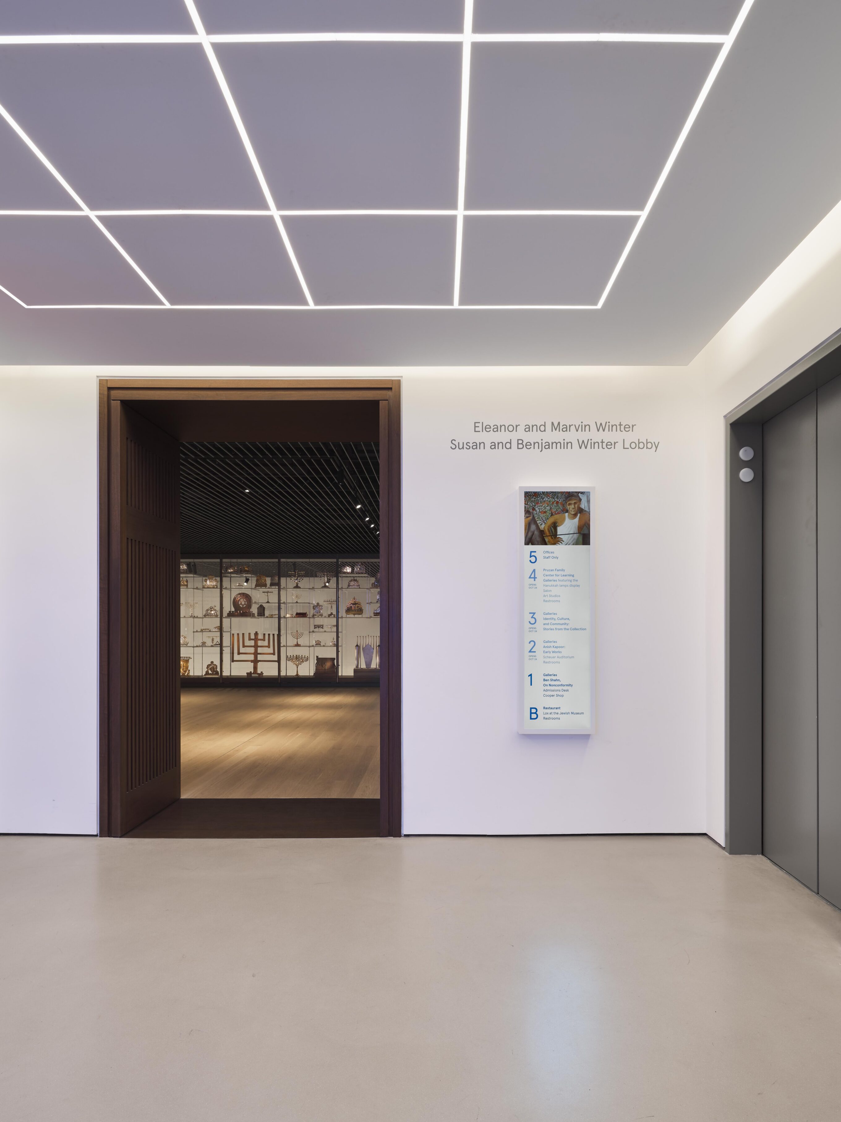 White elevator lobby with gridded ceiling lights