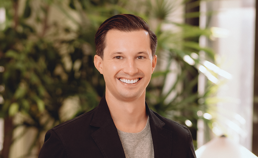 Man in a black suit jacket standing in an office