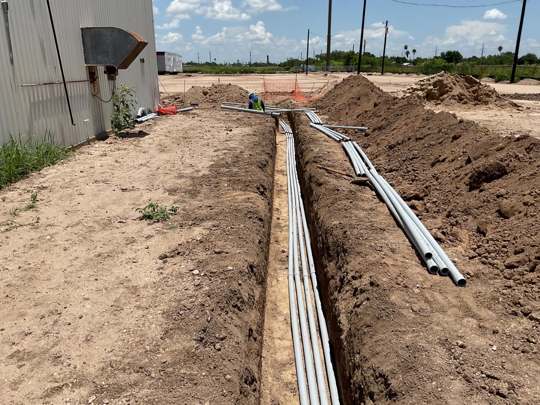pipes being laid outside in a dirt trench