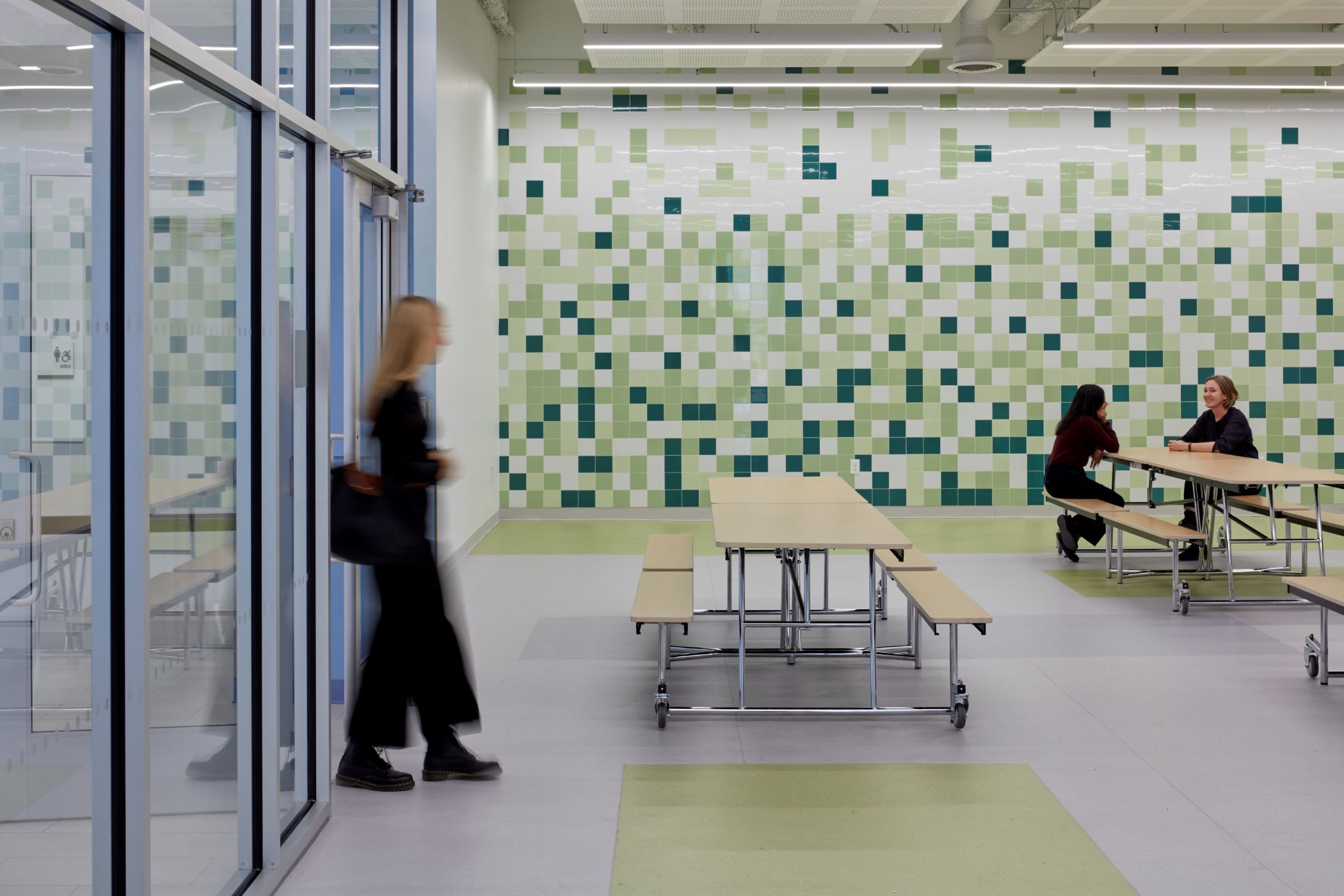 Teachers in the cafeteria with square design on wall