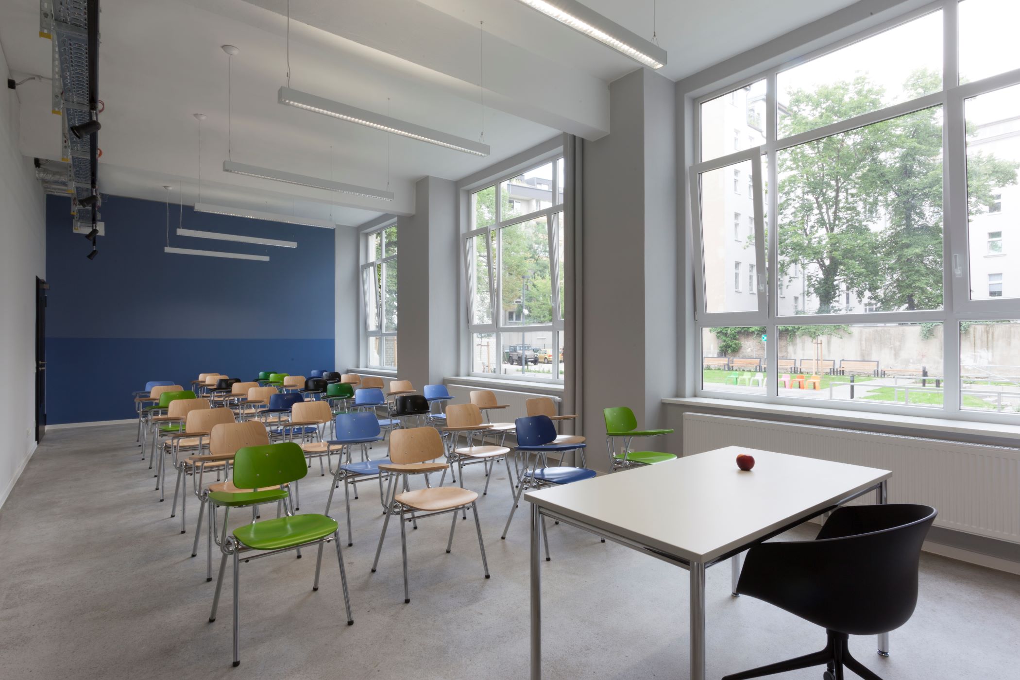 classroom set up with multi-colored chairs and large windows
