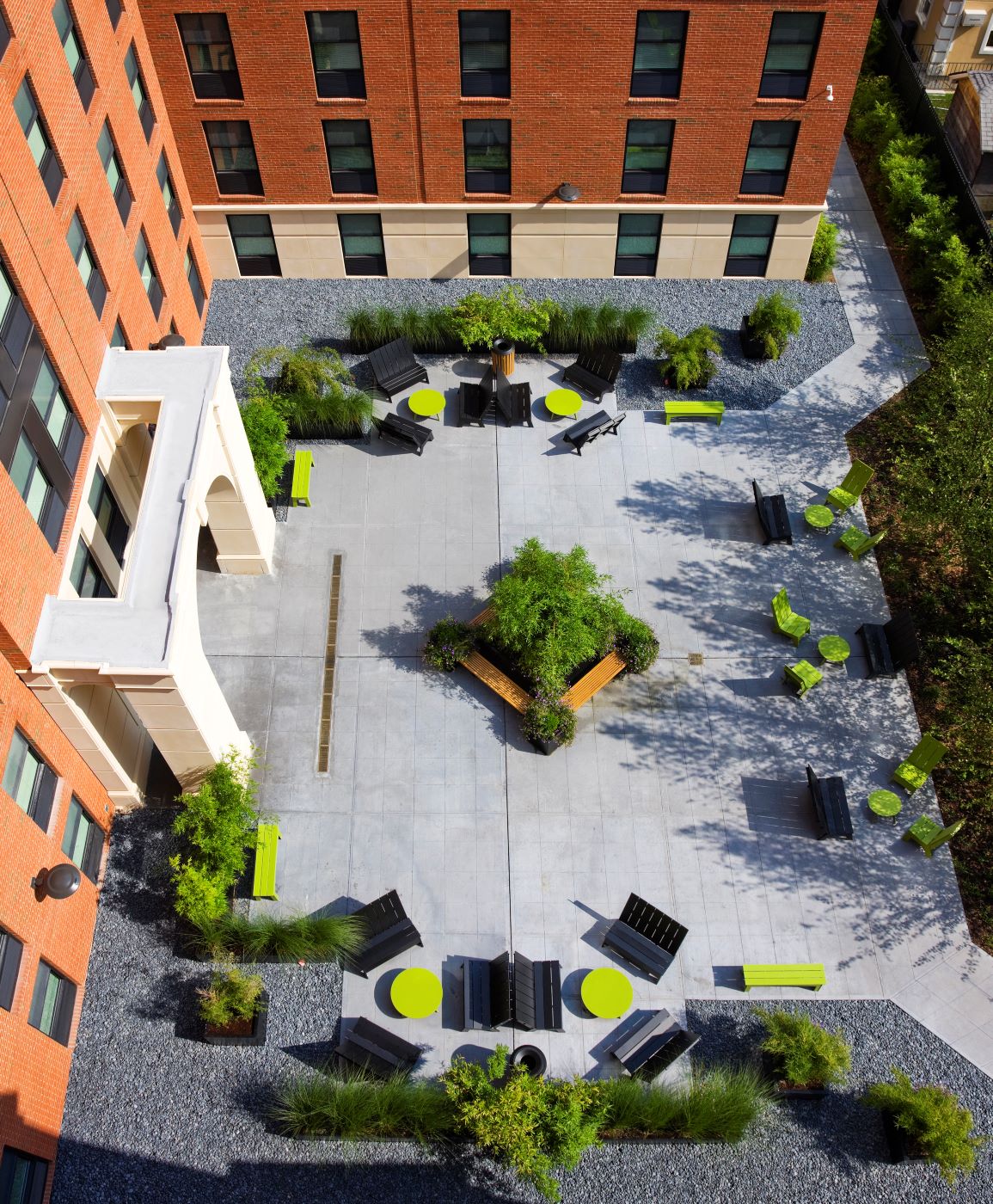 aerial shot of a paved courtyard with green and black seating
