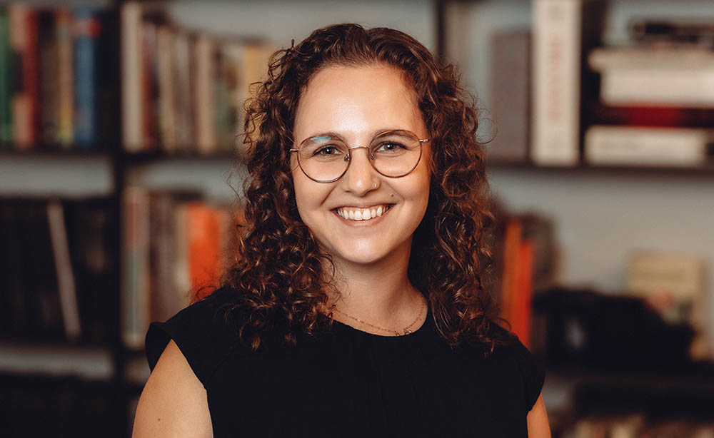 employee headshot in front of a bookcase