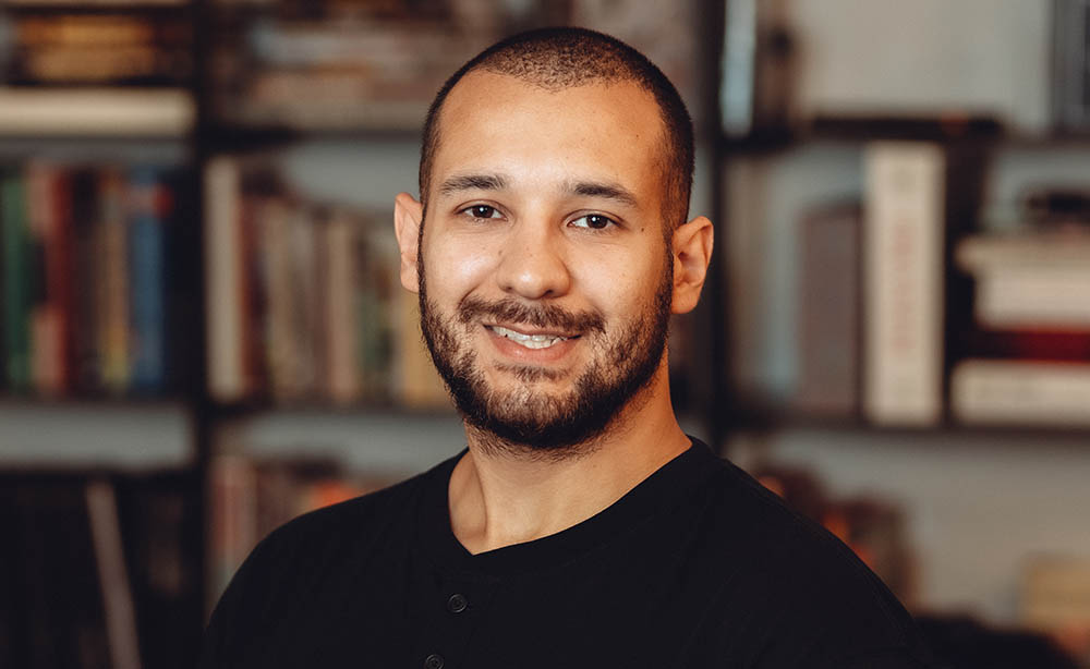 employee headshot in front of a blurry bookcase