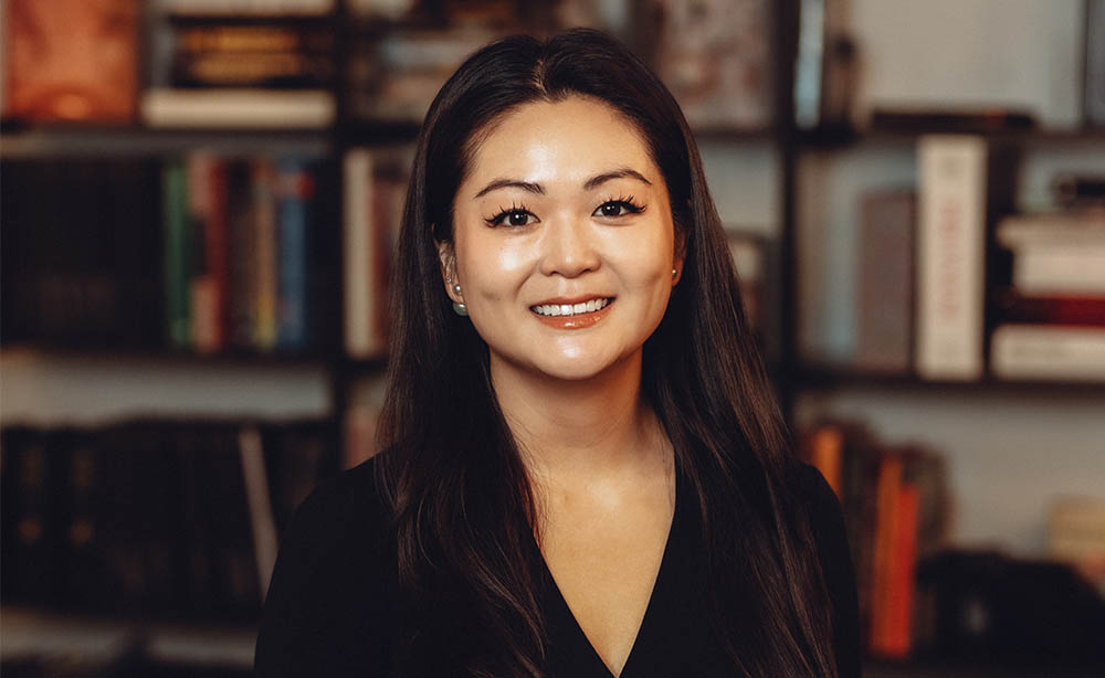 employee headshot in front of a blurry bookcase