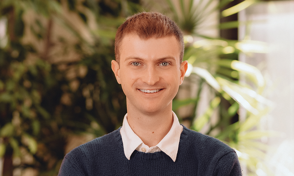 Man in blue sweater standing in office