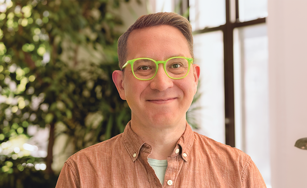 Man with green glasses in office