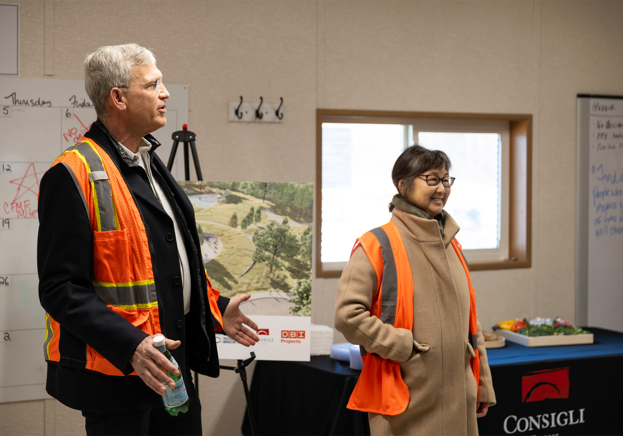 Two people wearing hi vis vests giving a speech