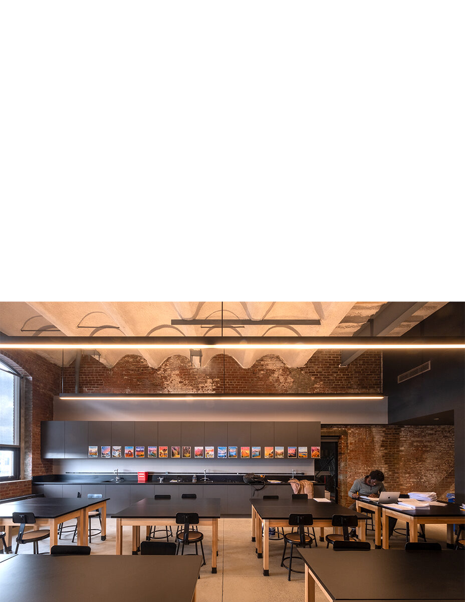 High school laboratory classroom with dark gray tabletops and cabinets within an old brick building