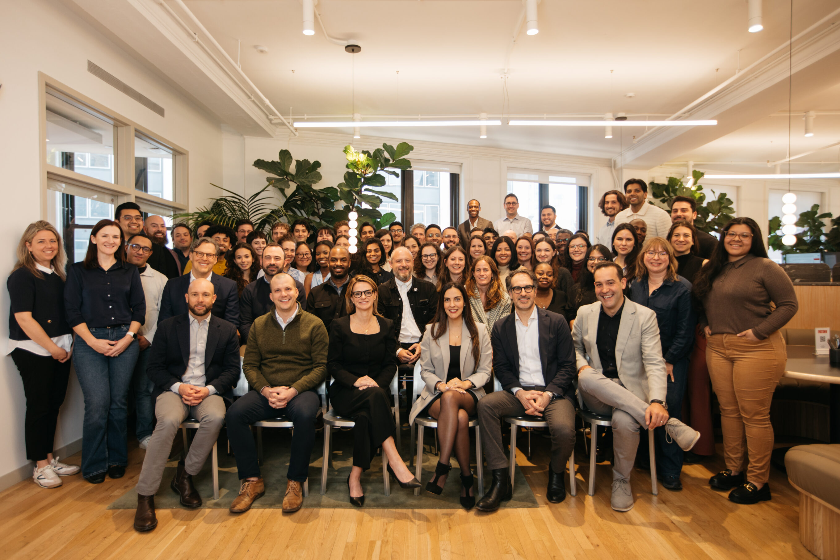 Photo of large group gathered in a plant-filled office